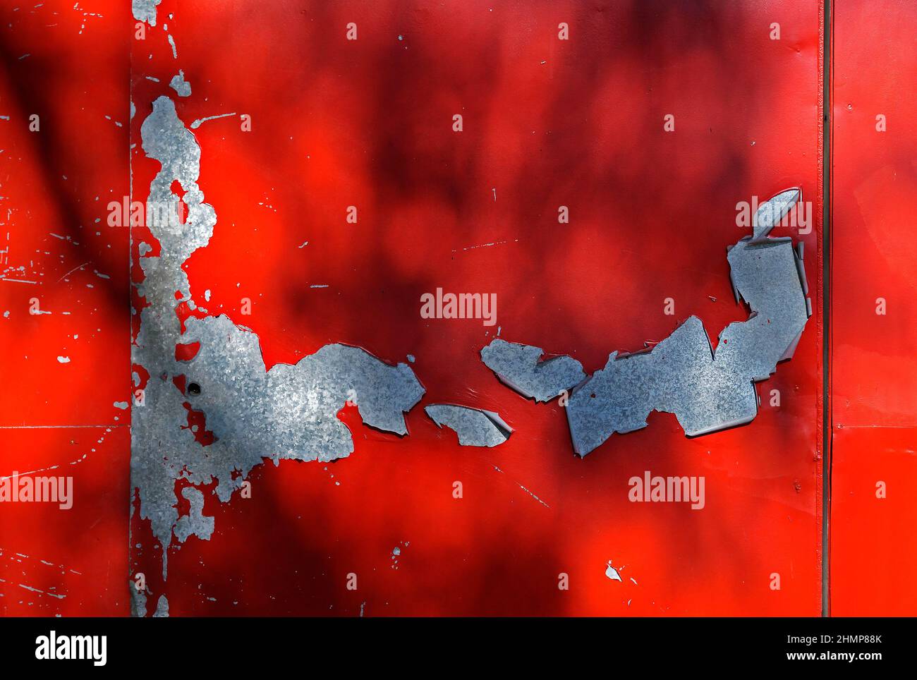 Damaged red metallic surface with peeling paint Stock Photo