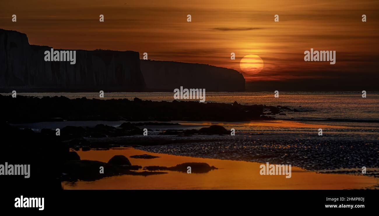 Coucher de soleil Ault Onival et ses falaises, ciel orangé au soleil couchant Stock Photo