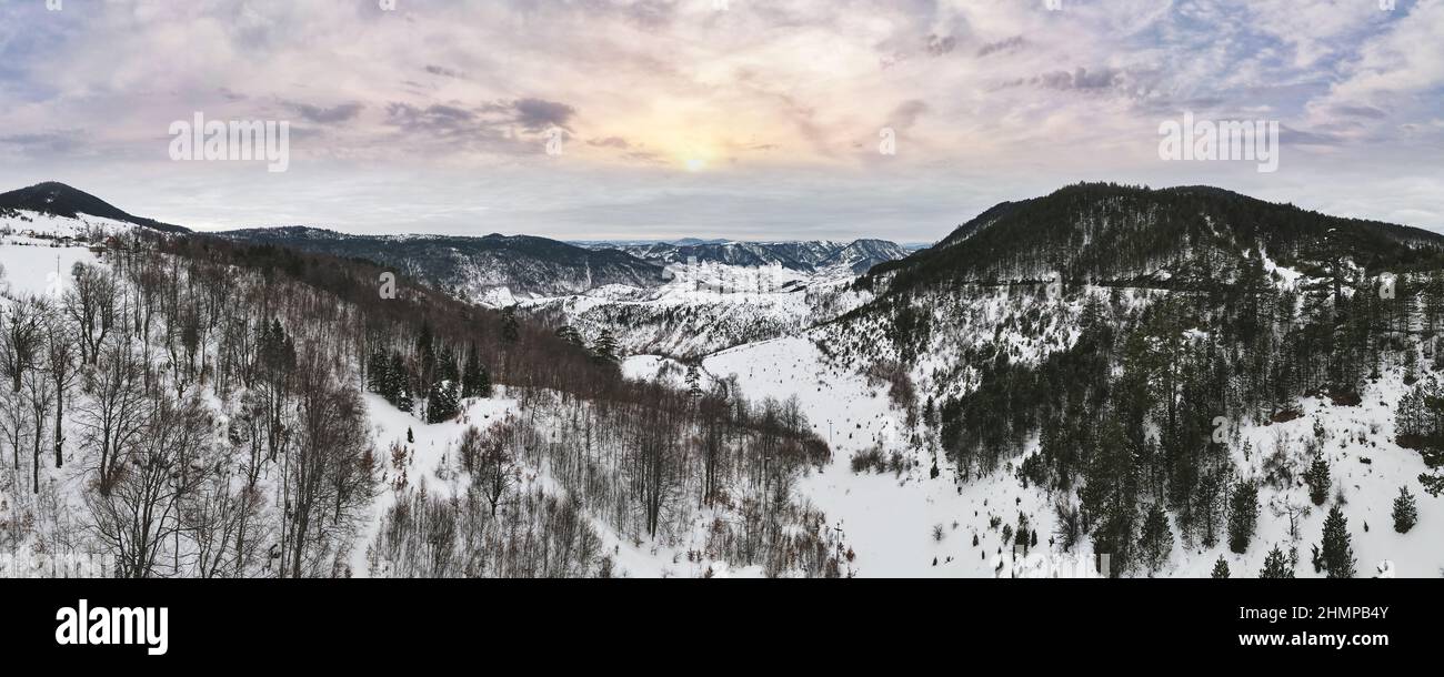 Snowy Mountain Landscape. Panorama of mountain range winter landscape with sunset sky on Zlatibor, mountain resort, Serbia, Europe. Stock Photo