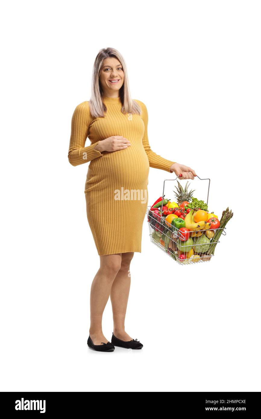 Pregnant woman holding a shopping basket with fruits and vegetables isolated on white background Stock Photo