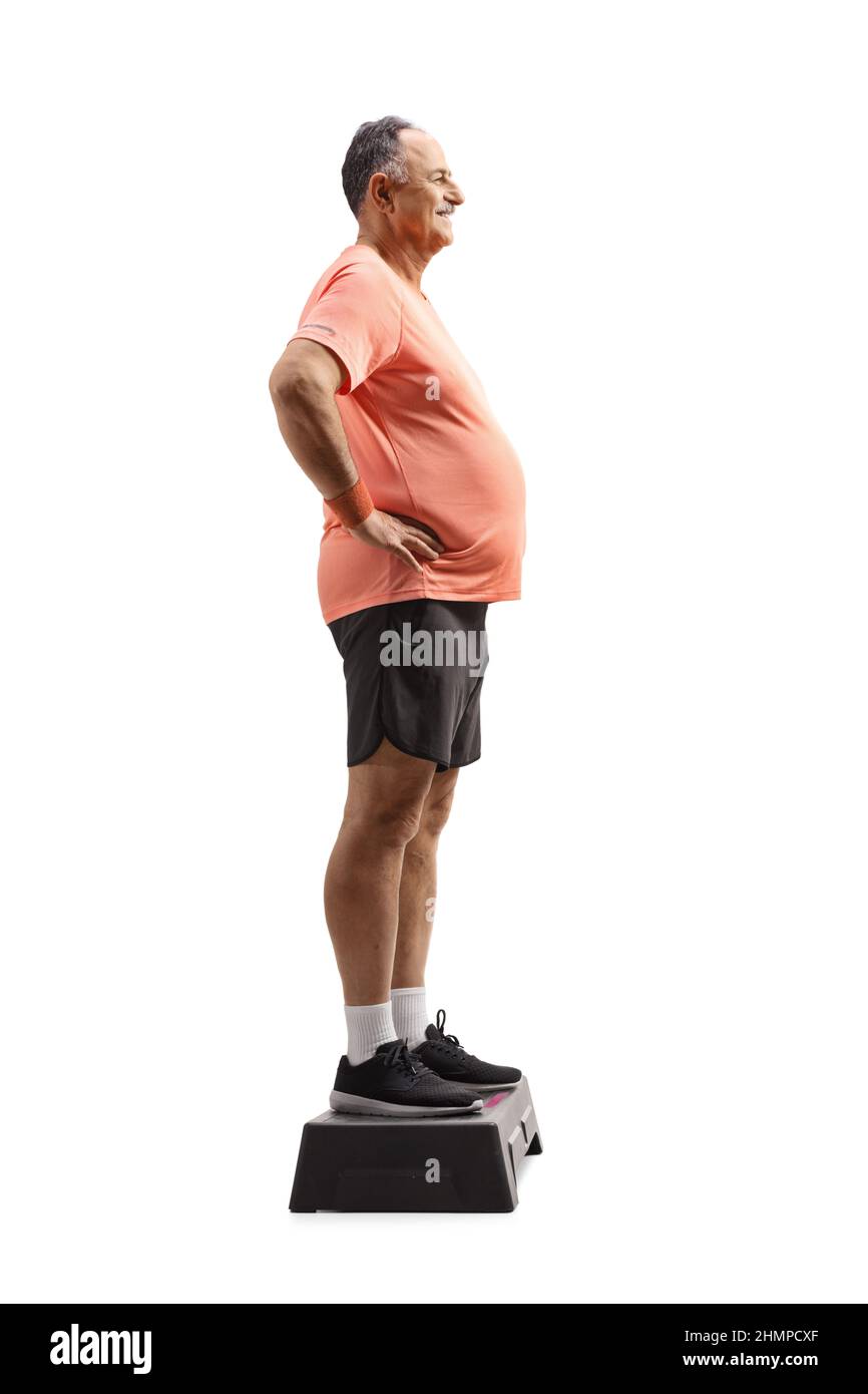 Full length profile shot of a mature man in sportswear standing on a stepper isolated on white background Stock Photo