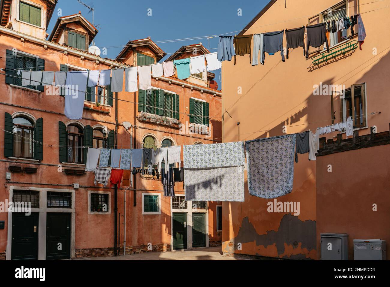 Laundry hanging out of typical Venetian facade,Italy.Narrow street with colorful buildings and clothes dry on rope,Venice.Clean clothes drying outdoor Stock Photo
