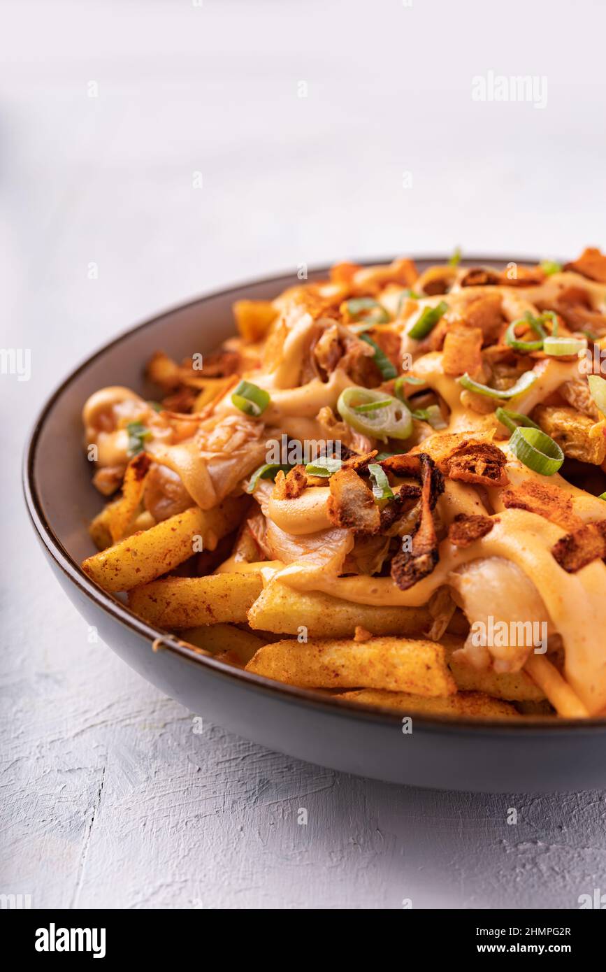 Loaded dirty vegan fries with pickled cabbage, hot mayo and crunchy coconut flakes Stock Photo