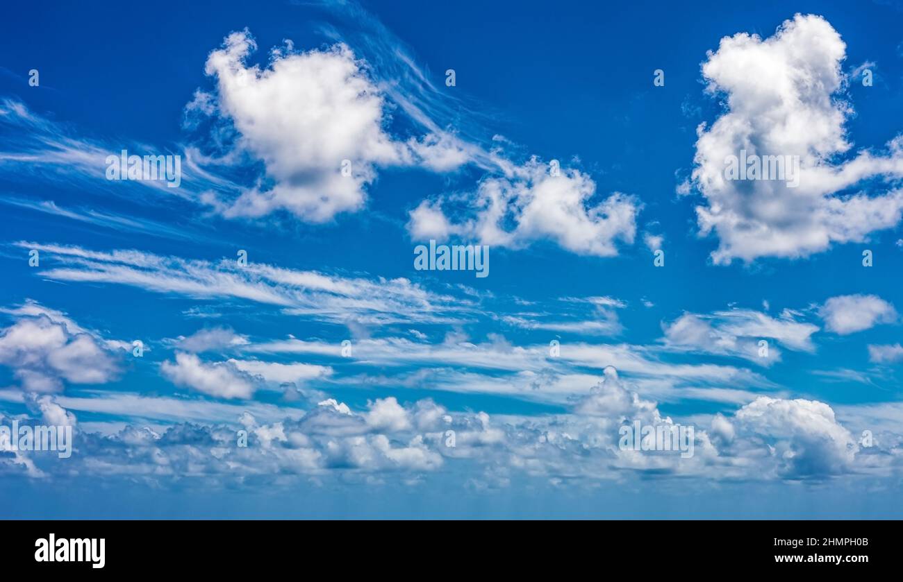 Daytime blue sky Background with white cumulus clouds. Soft focus. Stock Photo