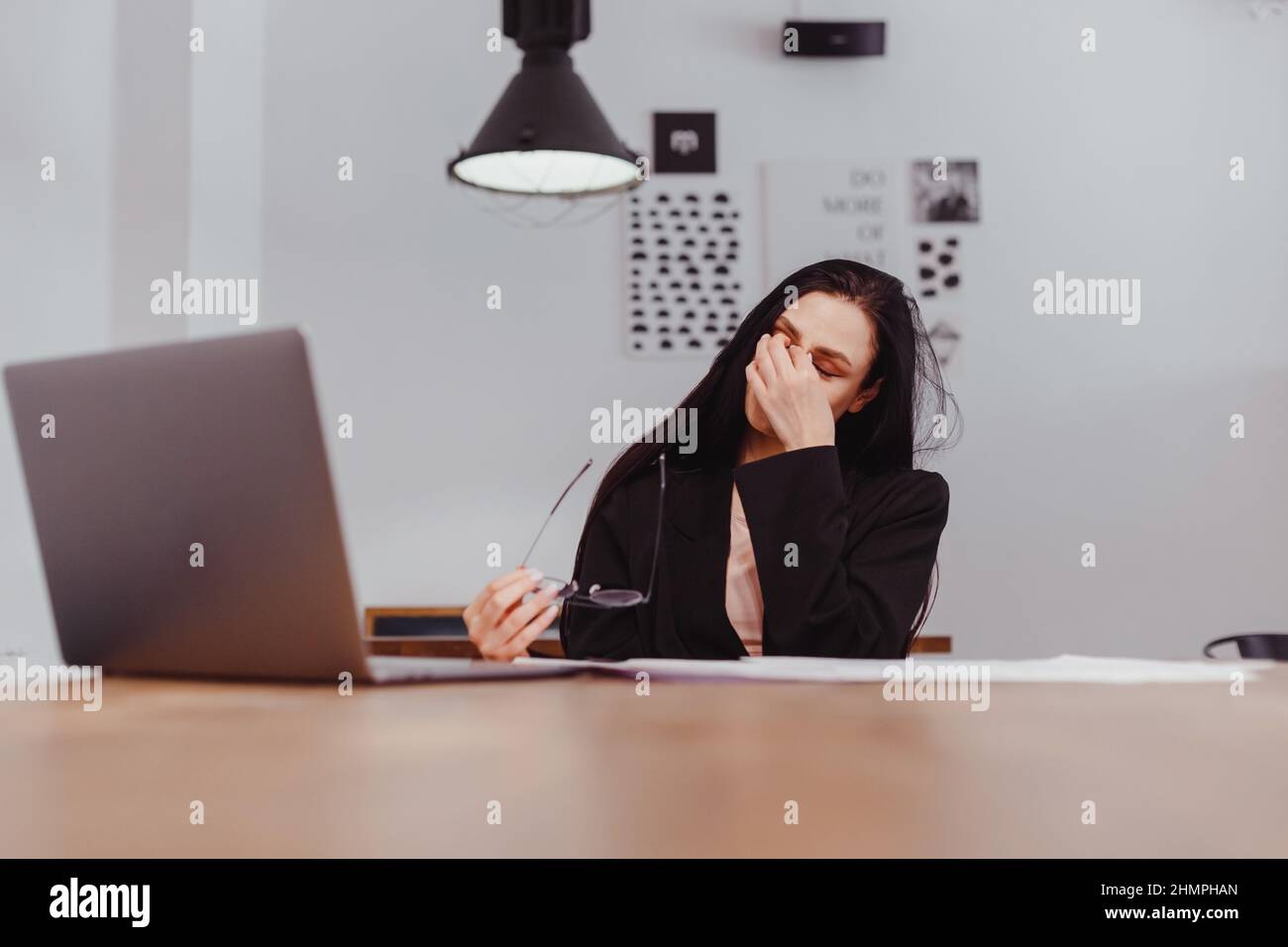 Young woman taking off glasses tired of computer work, suffering from