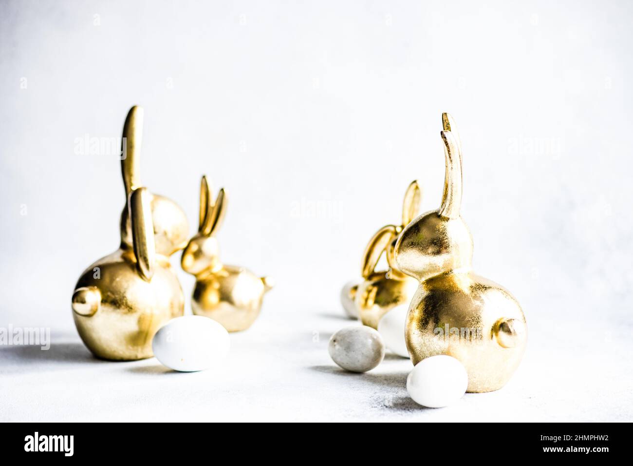 Golden Easter bunny decorations and Easter eggs on a table Stock Photo