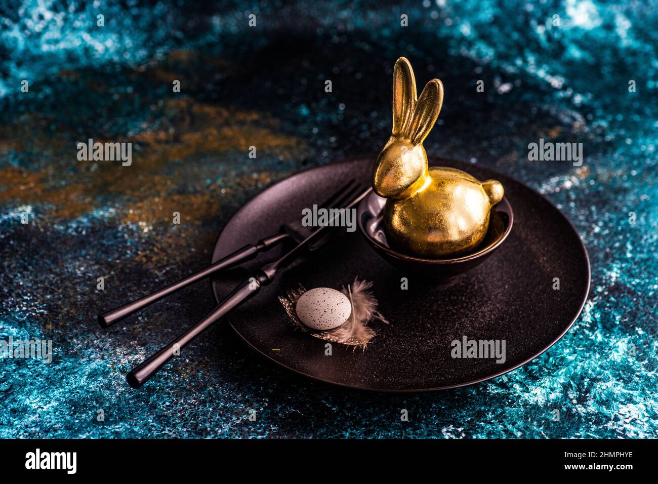 Easter place setting on a table with a golden Easter bunny and Easter egg Stock Photo