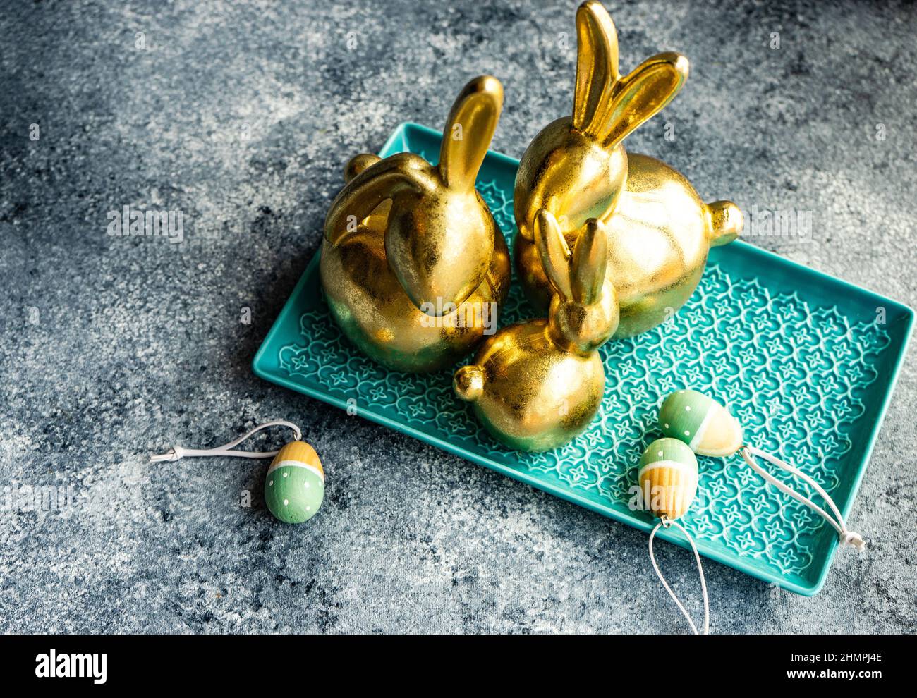 Festive golden Easter bunny decorations on a table with Easter eggs Stock Photo