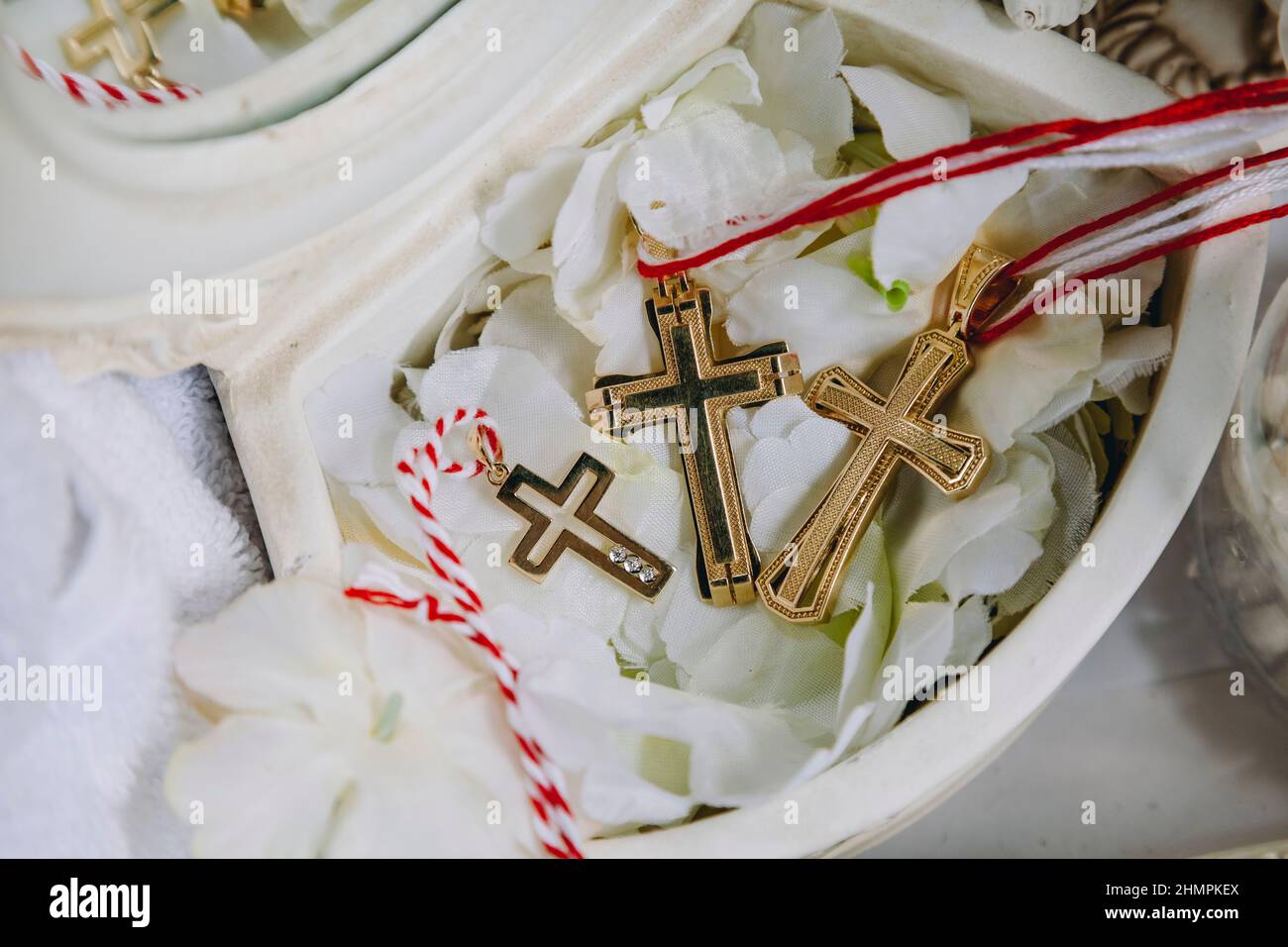 Three gold small christening crosses during the baptism ritual in ...