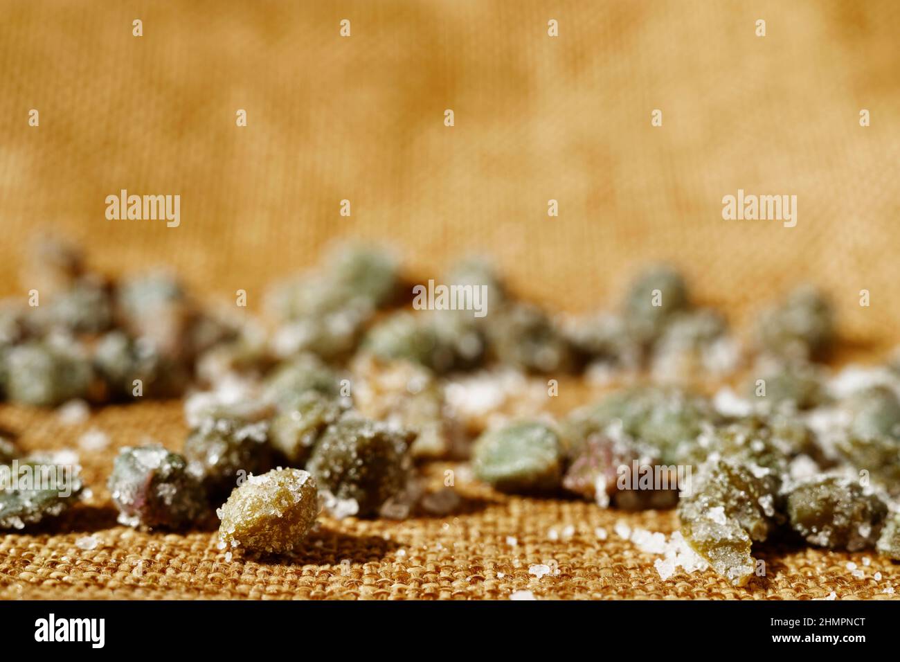 Beautiful green salted capers on brown cotton cloth Stock Photo
