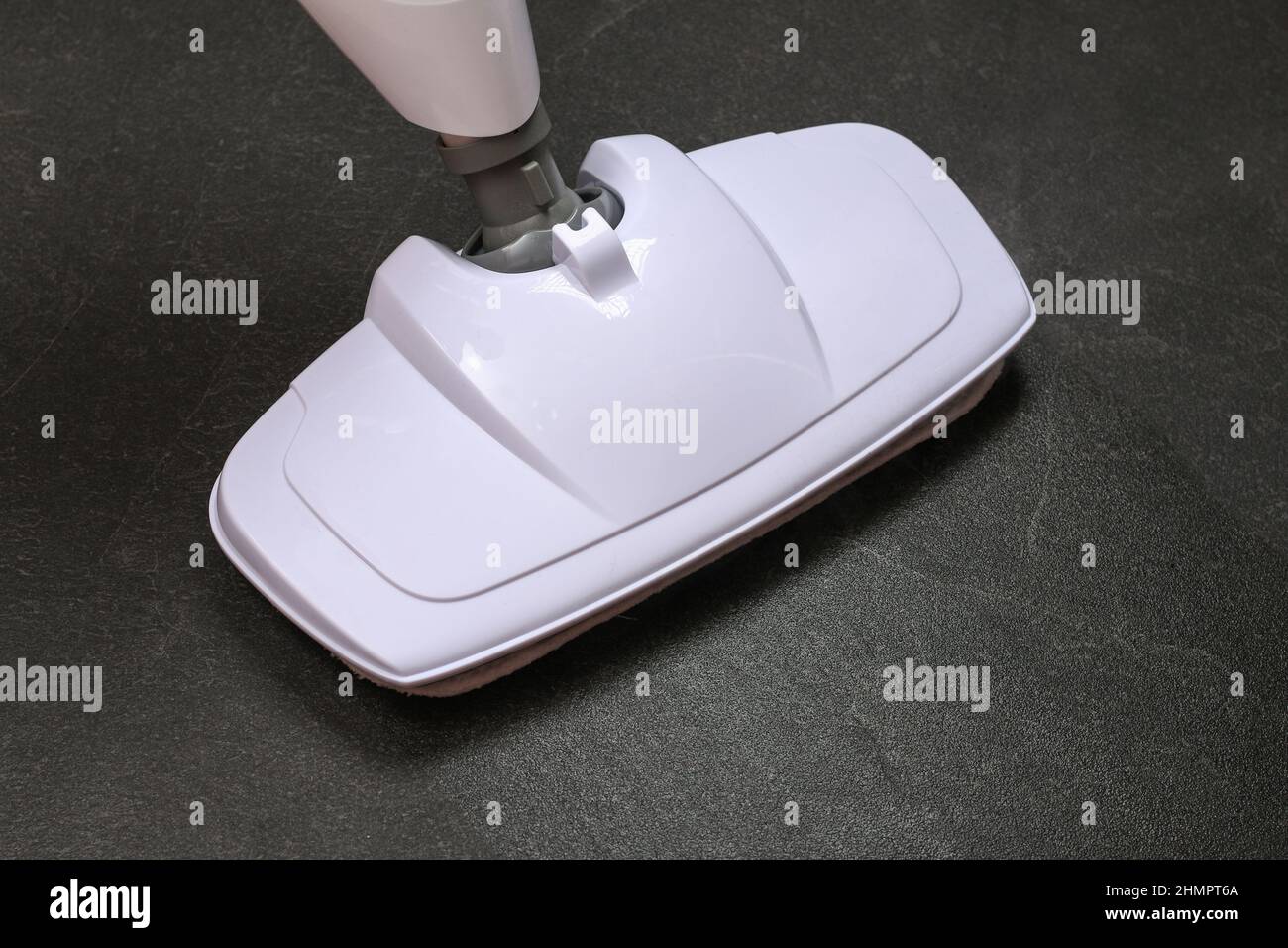 A man washes black porcelain stoneware with a steam mop. Killing germs