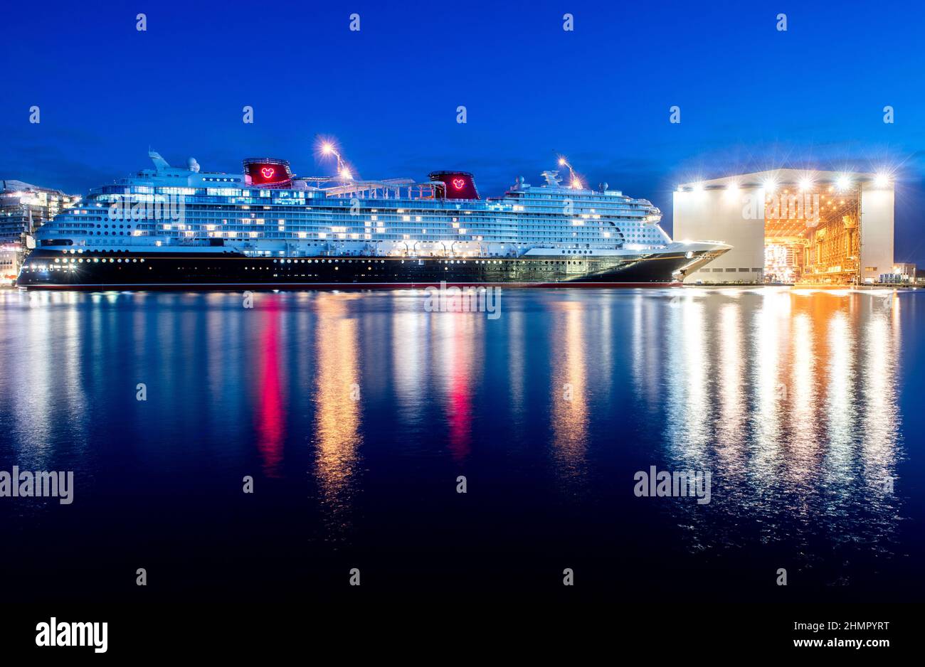 Papenburg, Germany. 11th Feb, 2022. The cruise ship "Disney Wish" lies in  the twilight at the fitting-out quay of Meyer Werft after being pulled out  of the building dock by tugs. The