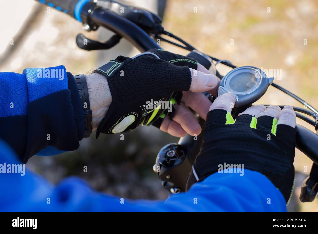 close up middle-aged bicyclist's hands using a stopwatch Stock Photo