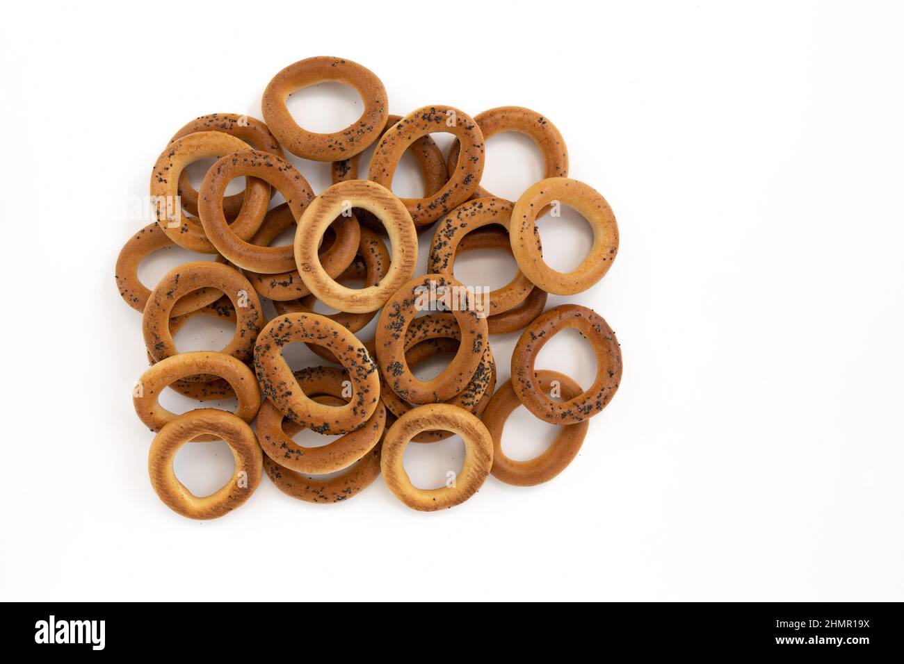 heap of bagels with poppy seeds isolated on white background, top view, food bakery concept Stock Photo