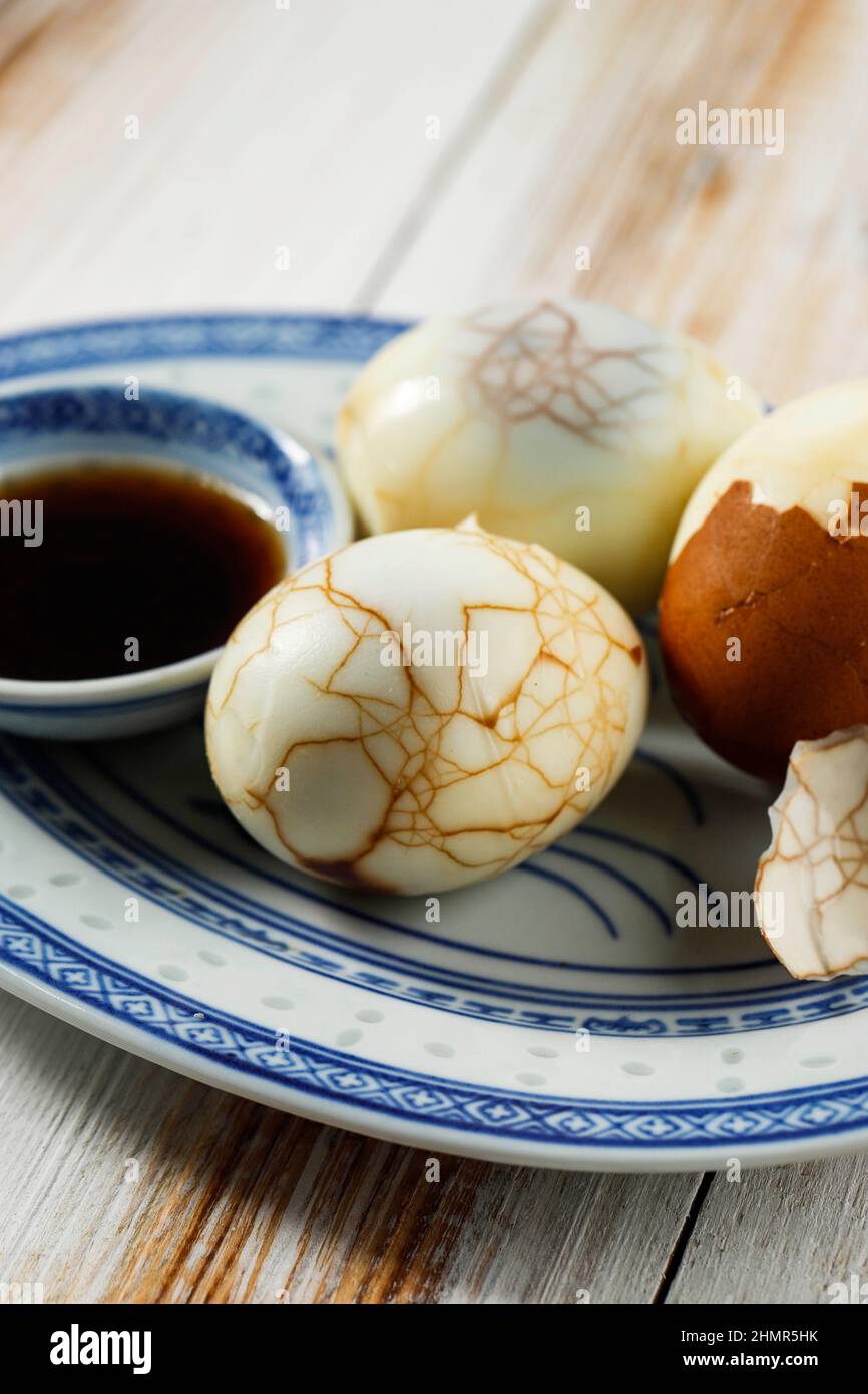 Close Up Chinese Food Boiled Marble Herbal Tea Egg on Rustic Wooden Table Top. Cha Ye Dan with Soy Sauce Stock Photo