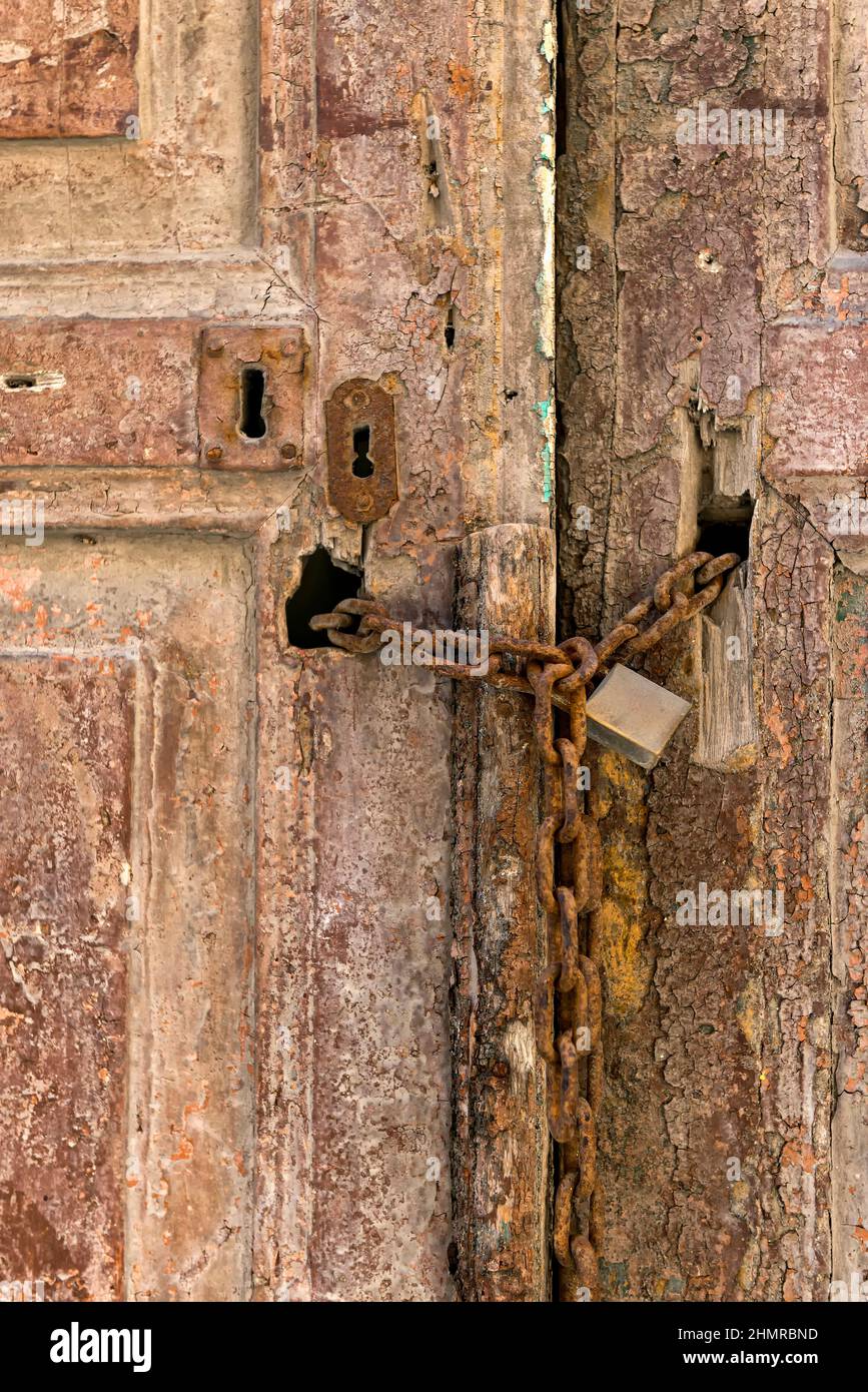 Old wooden door with rusty chain and lock Stock Photo