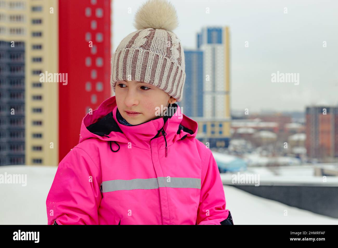 Portrait of a teenage girl in bright clothes. Copy space. Winter urban background Stock Photo