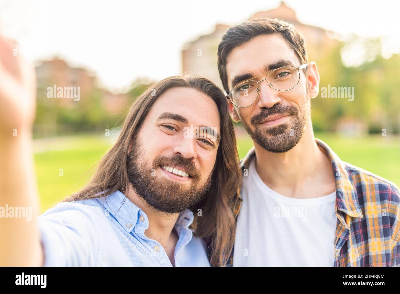happy gay couple taking a selfie in the park Stock Photo
