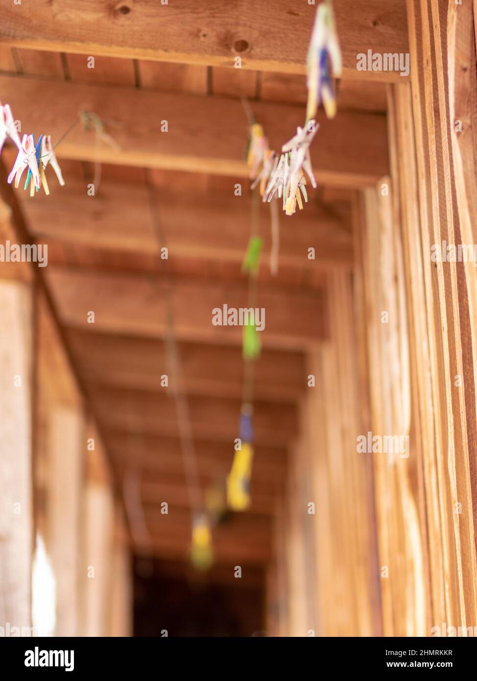 clothes pegs on clothesline, blurred background of wooden boards, close