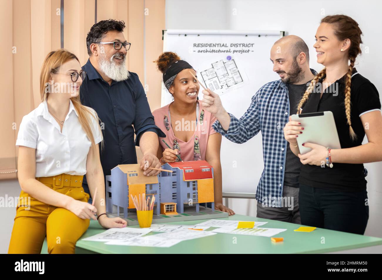Team of mixed multiethnic architects working on construction plans in meeting room Stock Photo