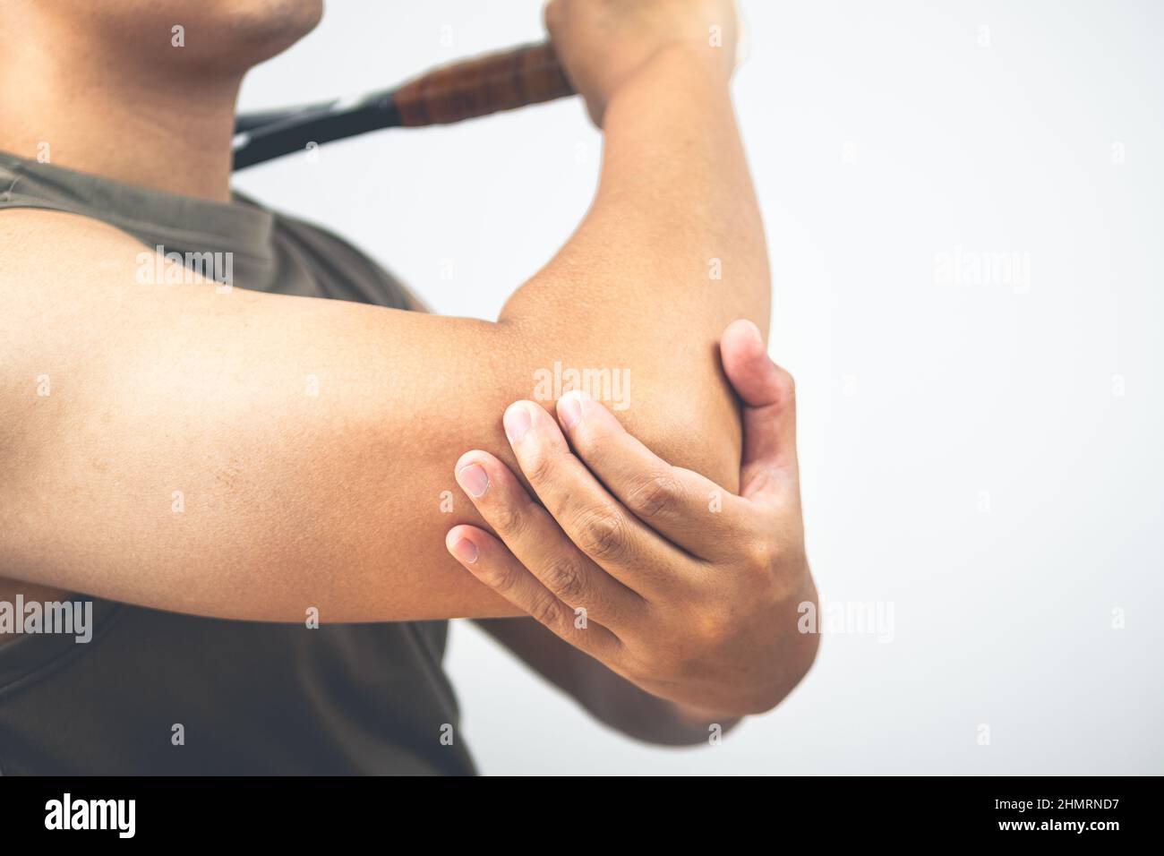 Tennis elbow injury concept. The man holds racket. Healthcare knowledge. Medium close up shot. Stock Photo