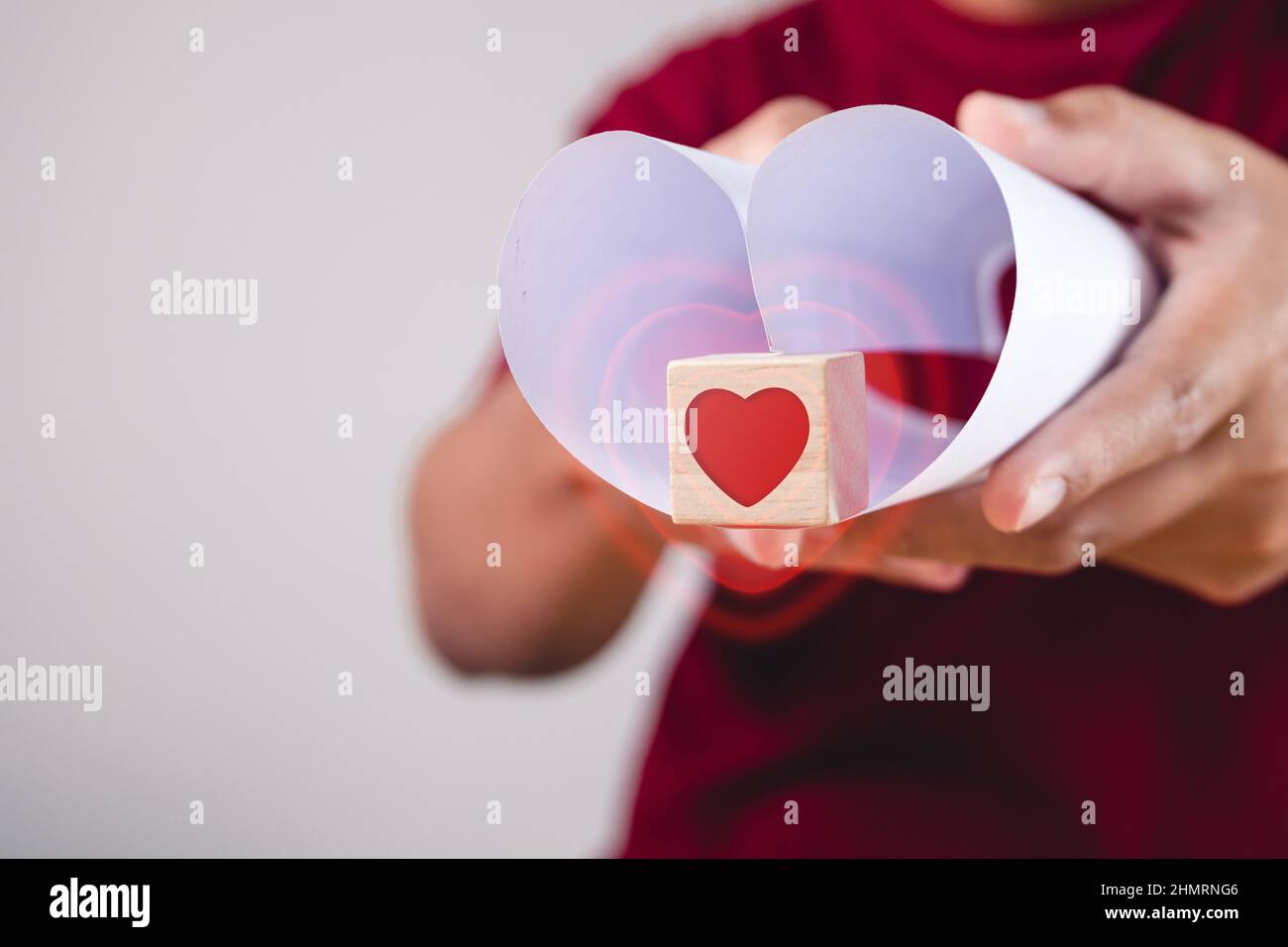 Valentine's day concept. Person holds heart shape paper and wood box with visual effect. Give a love to you. Stock Photo