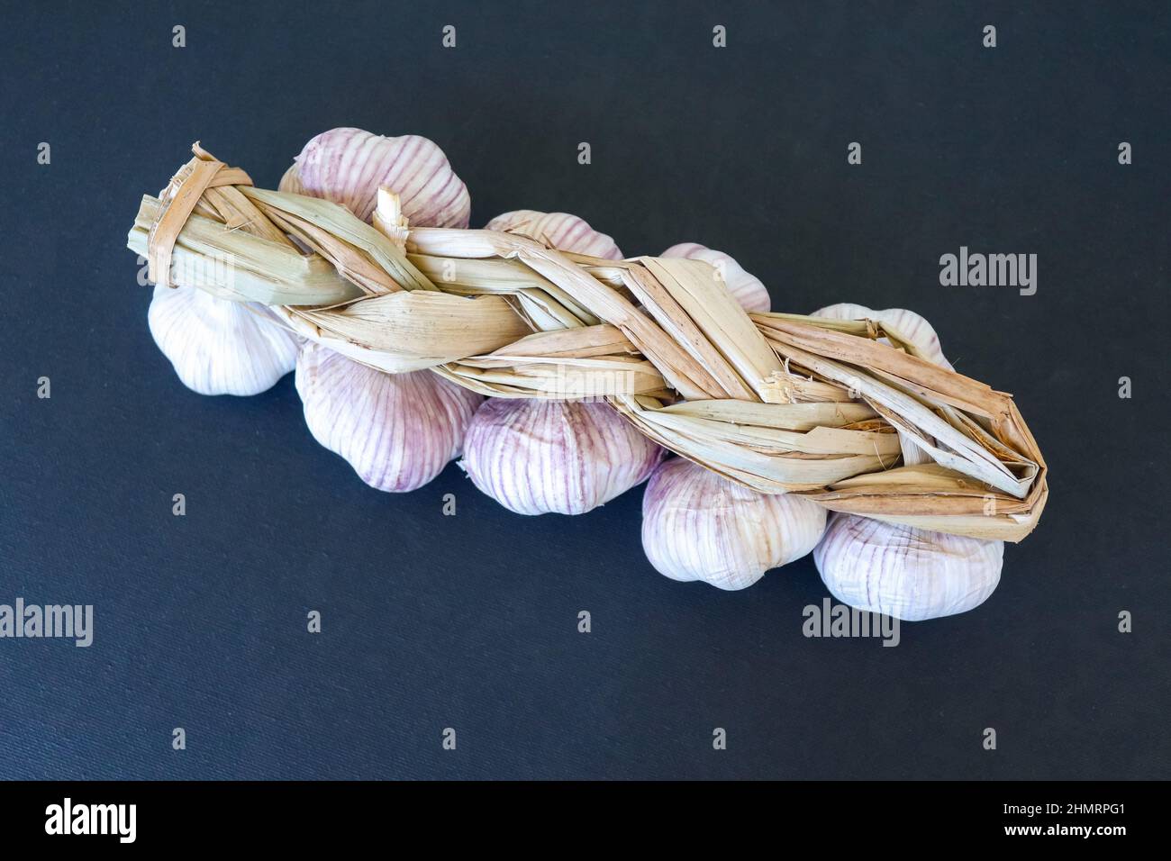 Garlic braid on black background Stock Photo