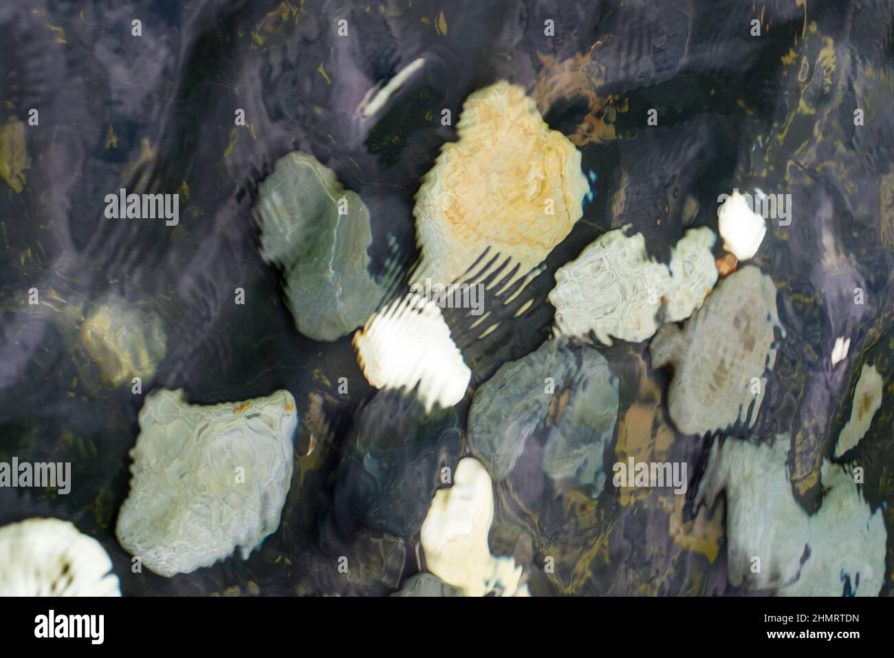 looking at the pebble stones in the water through wobbling surface Stock Photo
