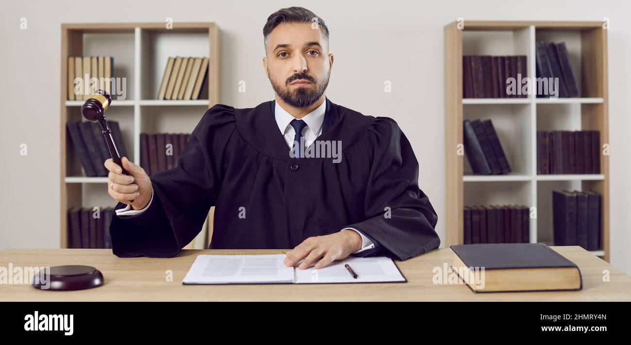 Male attorney in courthouse hit gavel Stock Photo