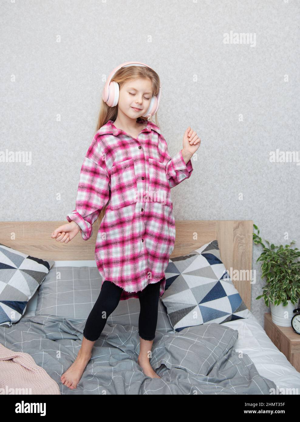 Adorable little girl in headphones enjoy with a music Stock Photo - Alamy