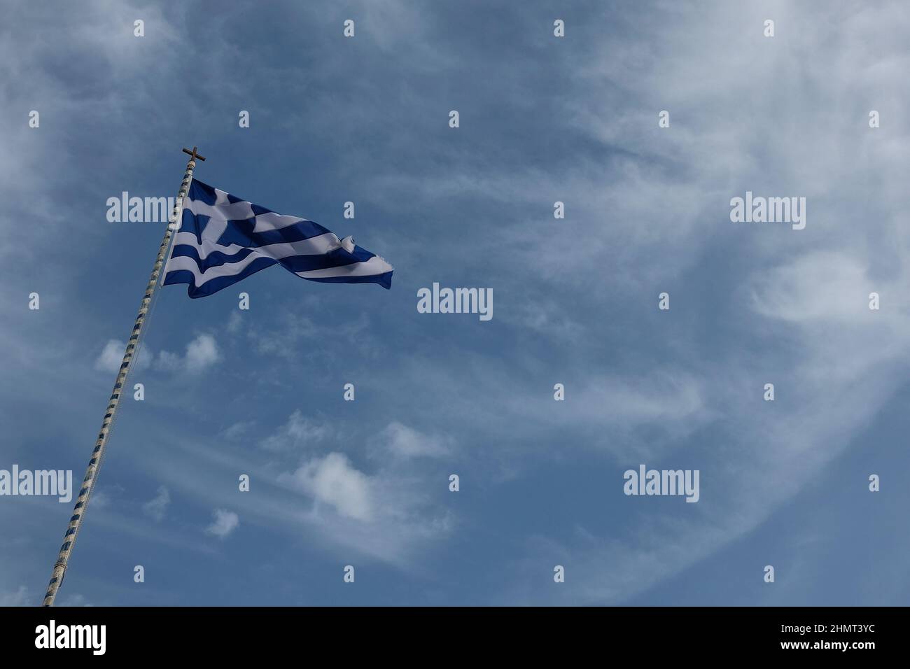 The greek flag waving in the wind against a beautiful blue sky Stock Photo