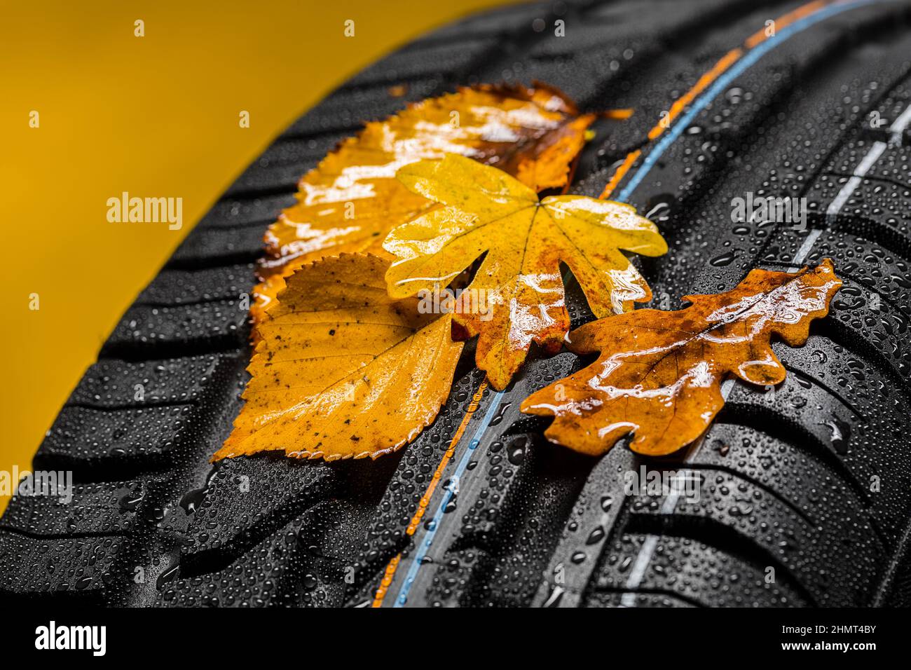 Canadian car car tires with autumn leafs and raindrops Stock Photo