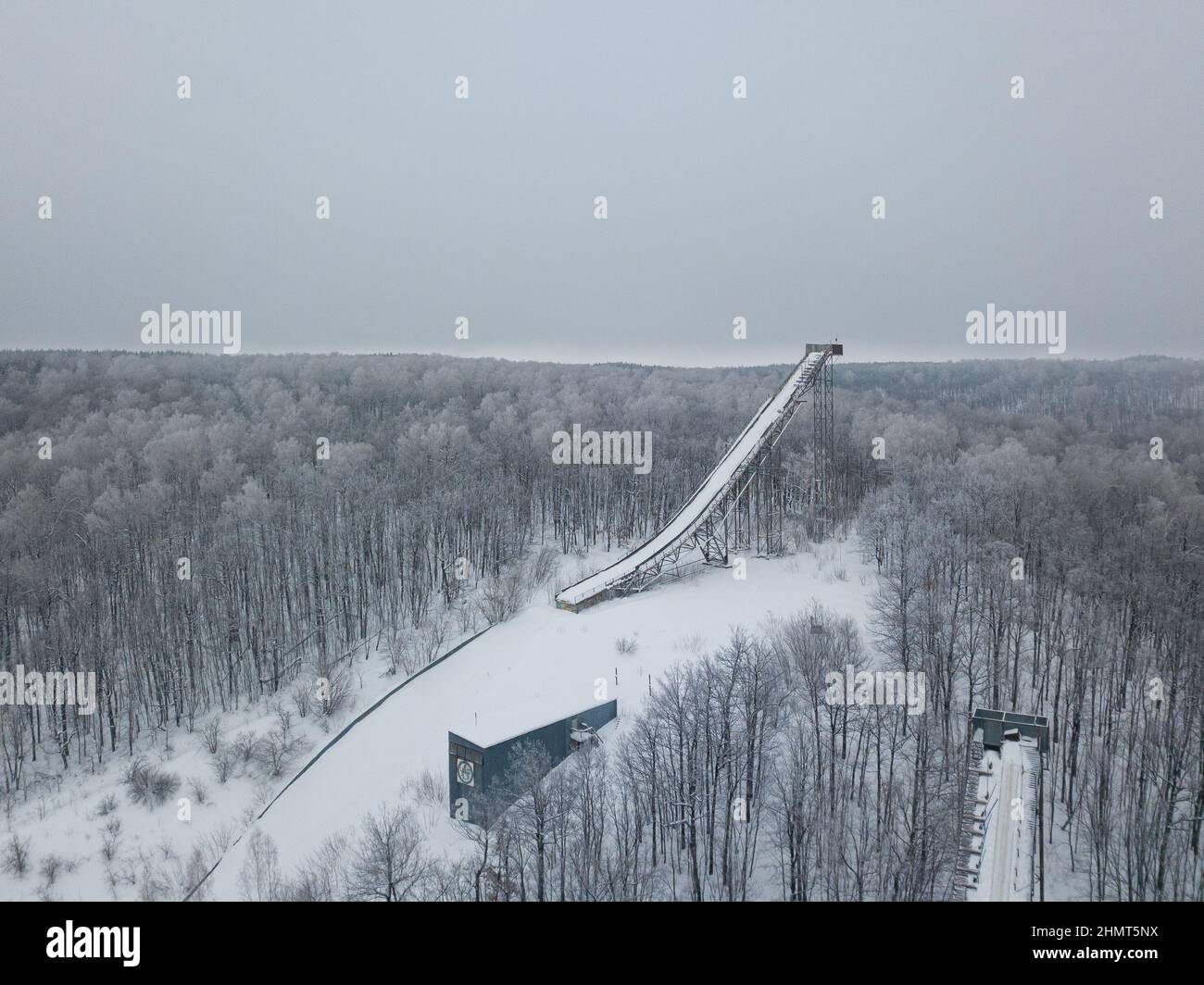 Ski jumping slopes or towers in Tatarstan, Russia. Ramps surrounded by snow-covered trees on a hill . Ski jumping ramp Stock Photo