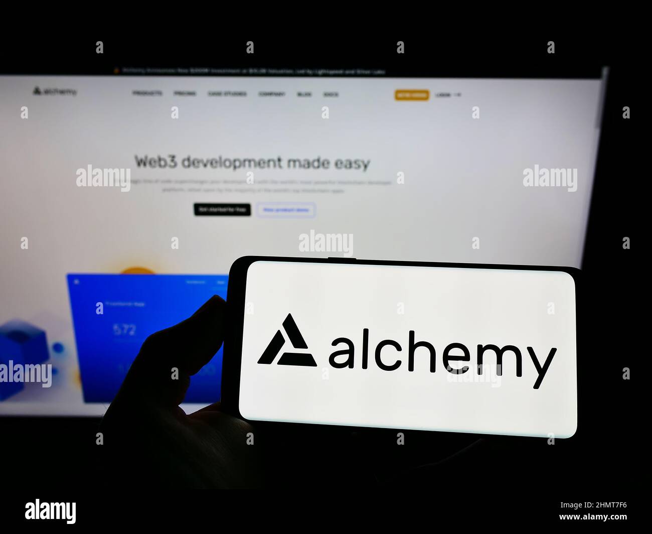 Person holding smartphone with logo of US software company Alchemy ...