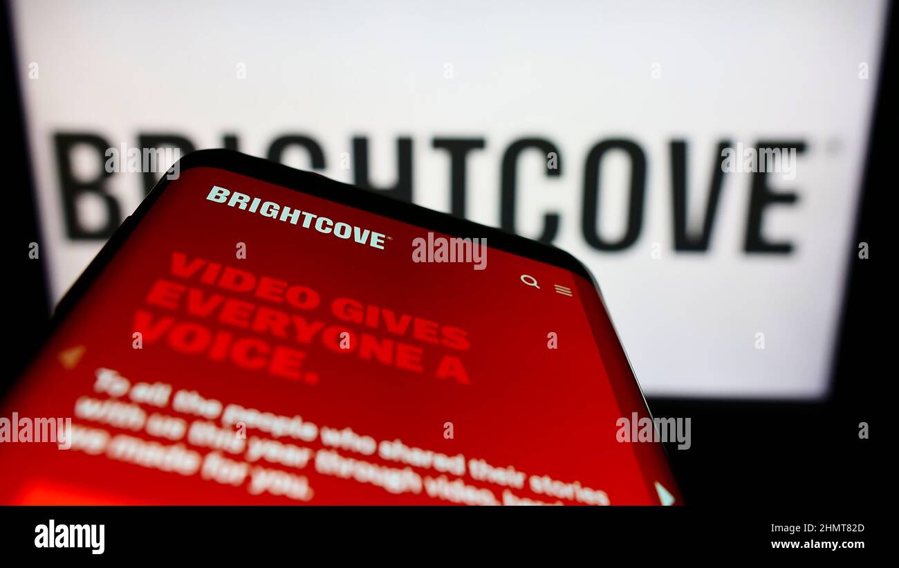 Smartphone with webpage of US video platform company Brightcove Inc. on screen in front of business logo. Focus on top-left of phone display. Stock Photo
