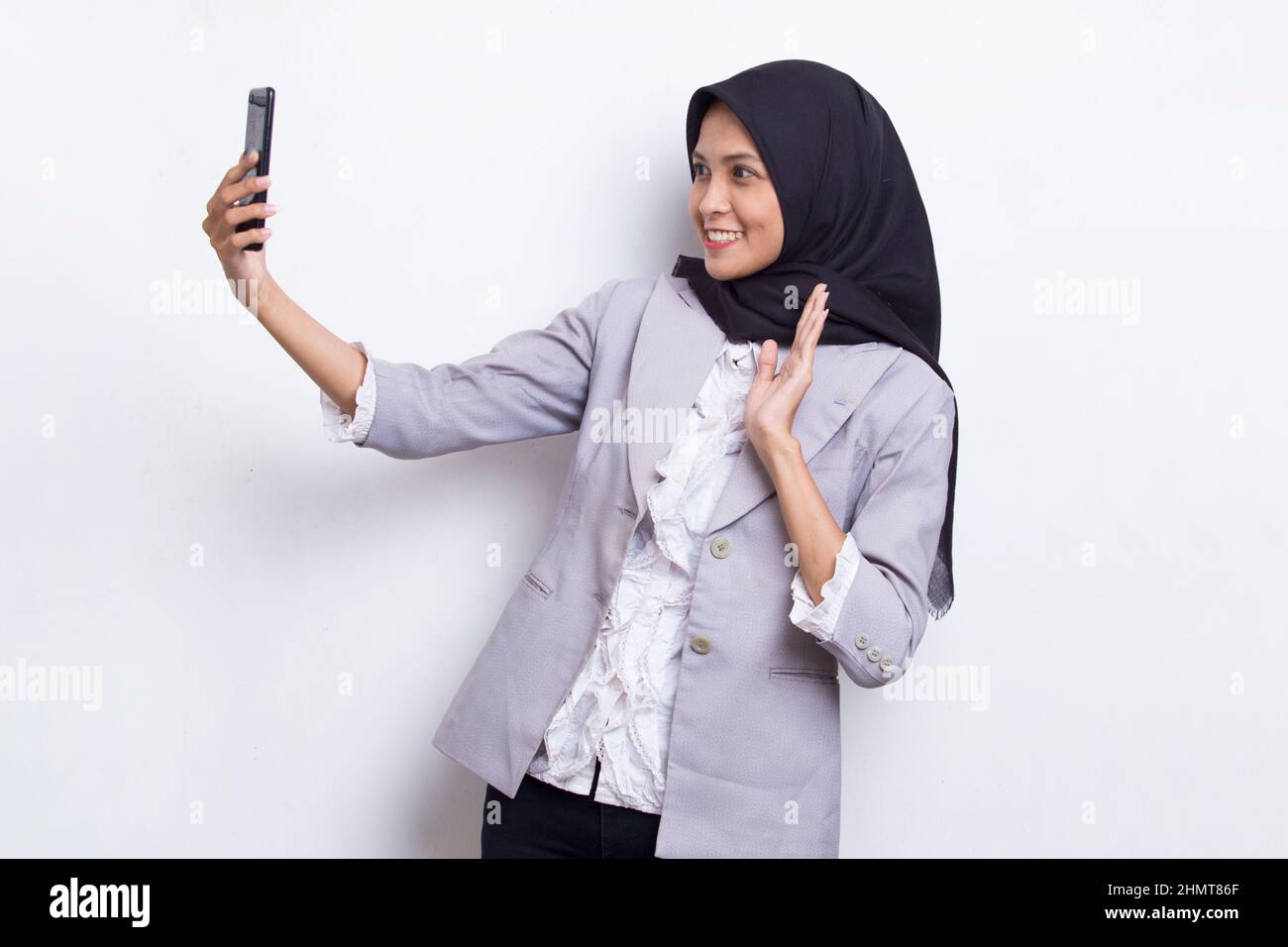 happy young asian beautiful muslim woman using mobile phone isolated on ...