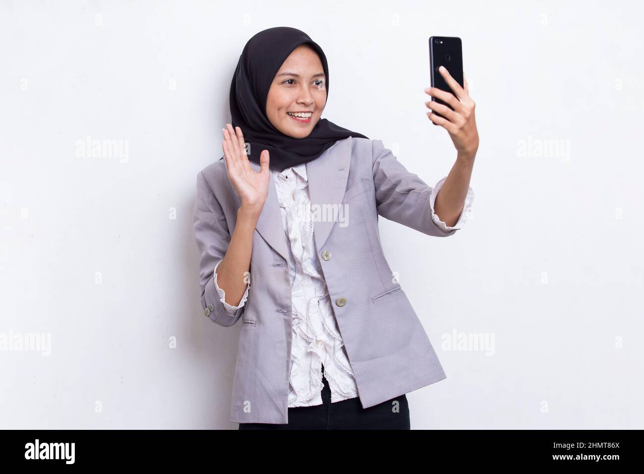 happy young asian beautiful muslim woman using mobile phone isolated on ...
