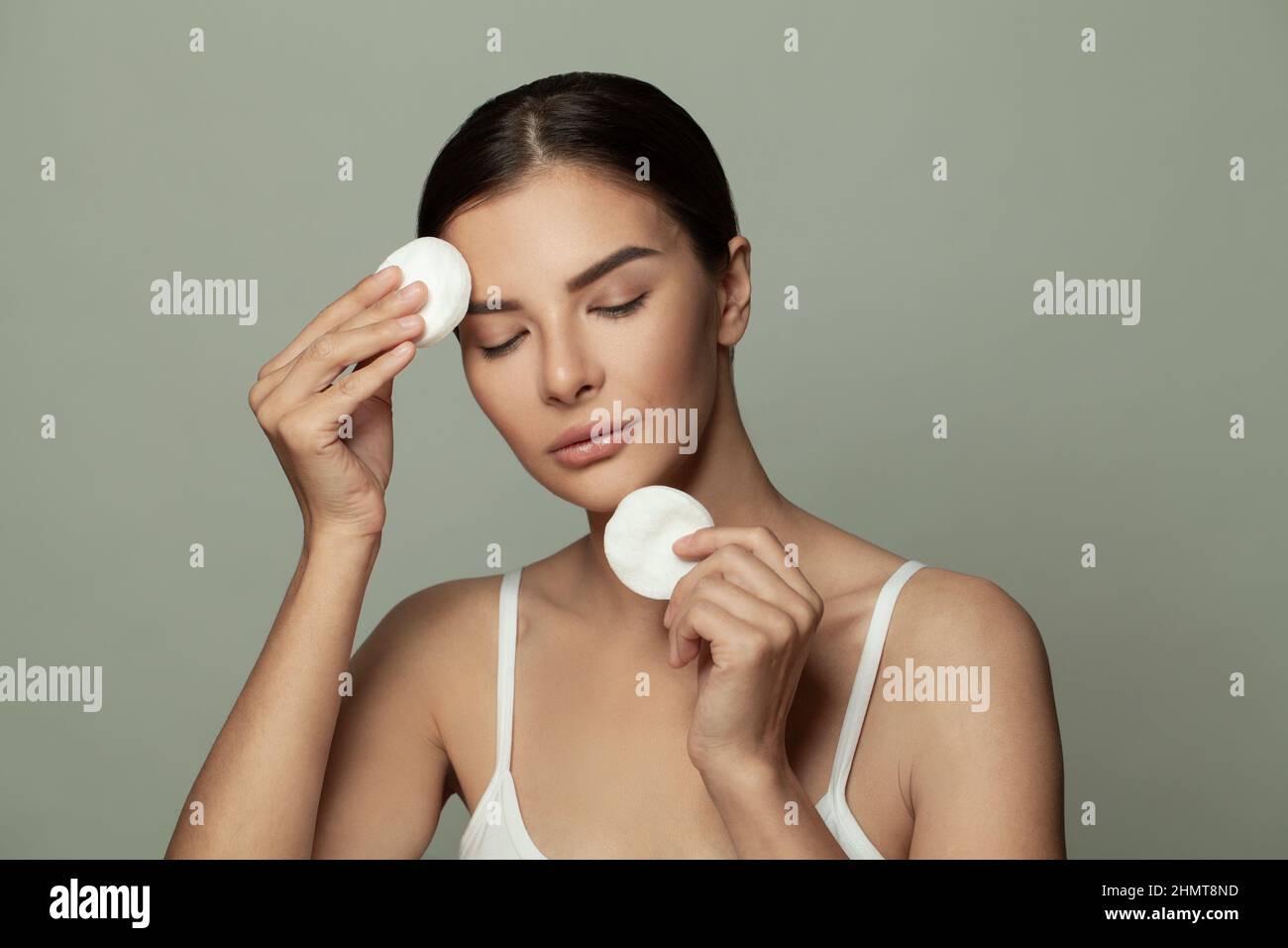 Pretty woman cleaning skin with cosmetic pad, makeup remove. Stock Photo