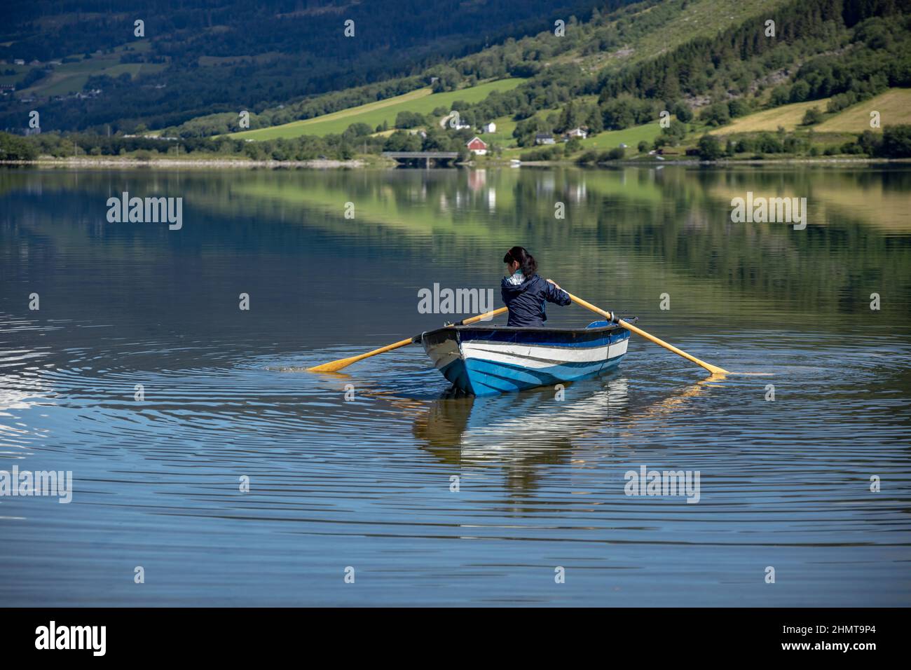 Woman fishing on a boat. Beautiful Nature Norway natural landscape. lovatnet lake Lodal valley. Stock Photo