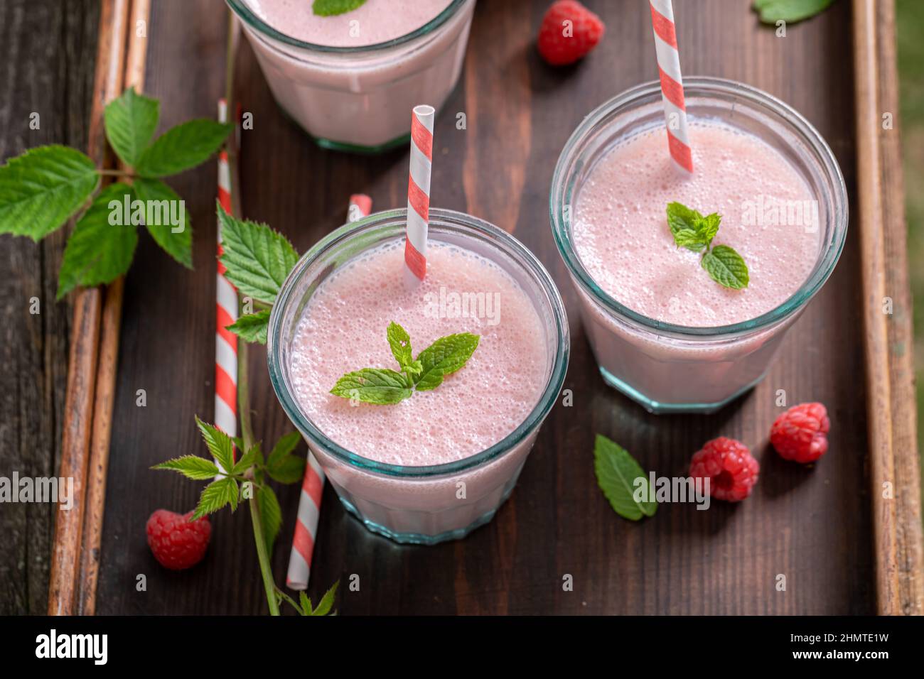 Sweet cocktail prepared from seasonal ingredients and milk. Raspberry smoothie as a natural energy drink. Stock Photo