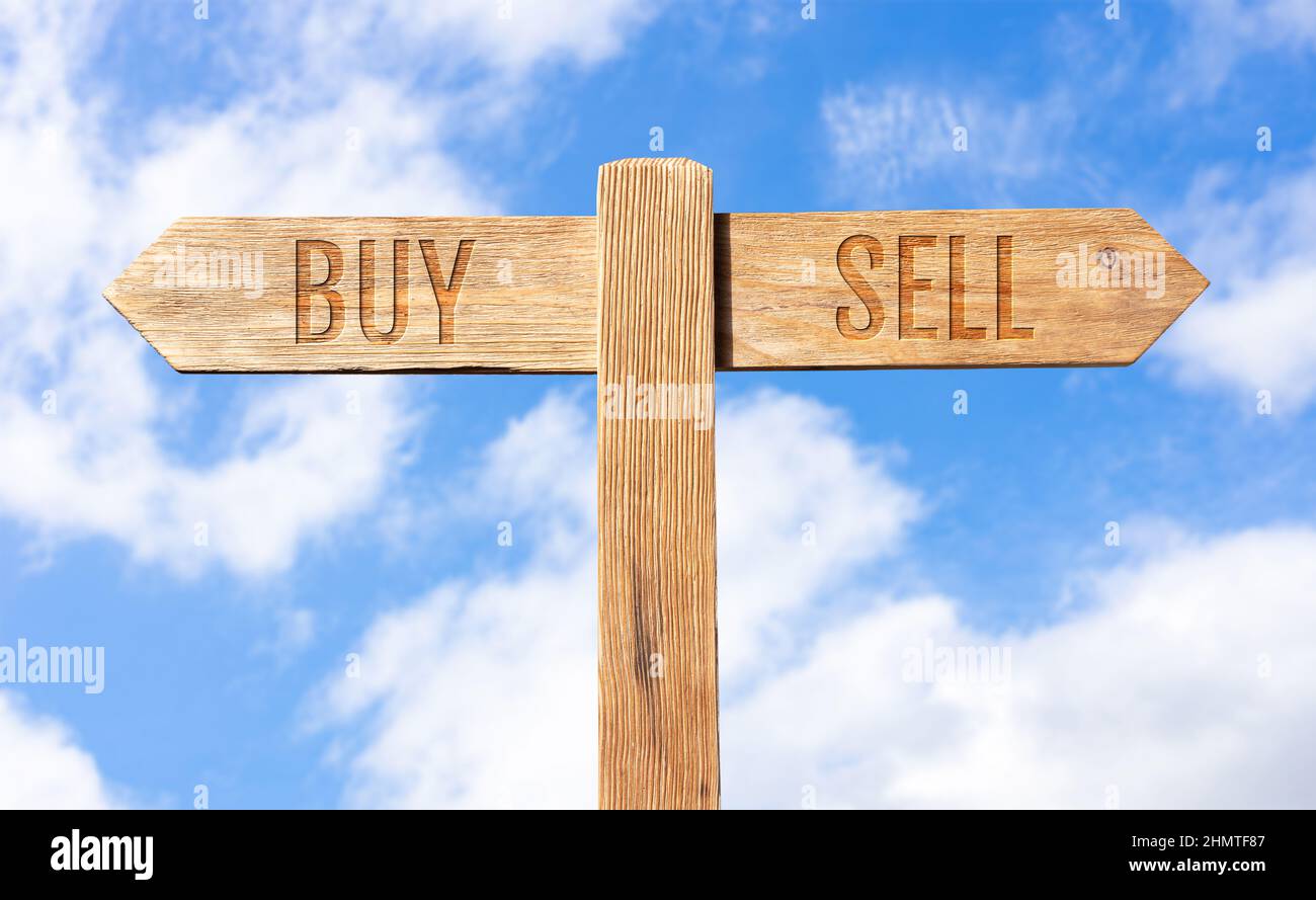 Buy or Sell concept. Wooden signpost with message on sky background Stock Photo