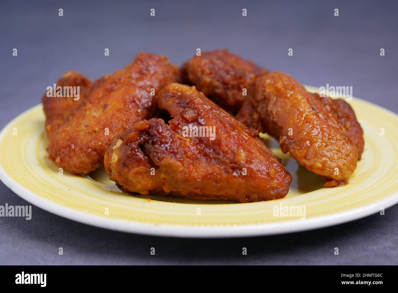 chicken wings on a plate on black background Stock Photo - Alamy