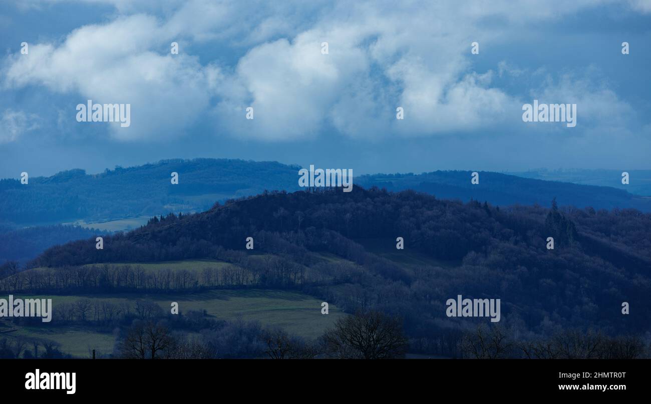 Blue landscape with hill and forest and cloudy sky Stock Photo - Alamy
