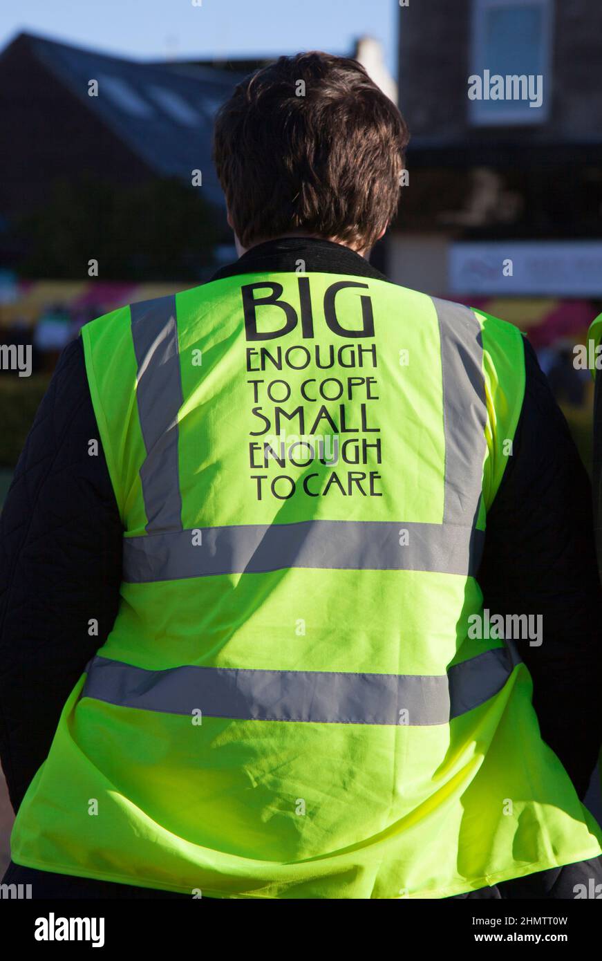 Slogan on back of hi-vis vest - Big enought to cope, Small enough to care. Stock Photo