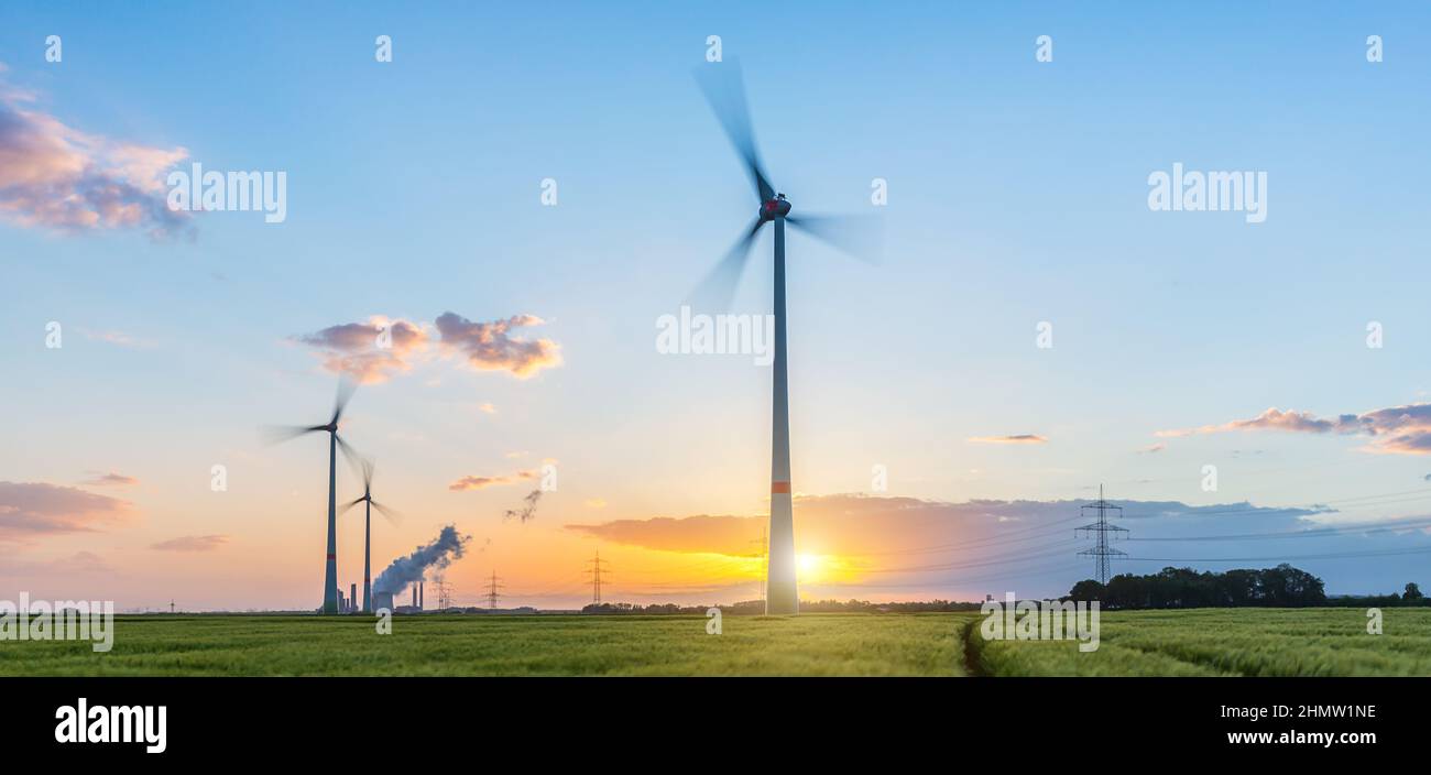 Wind turbines with power plant at sunset with cloudy sky Stock Photo ...
