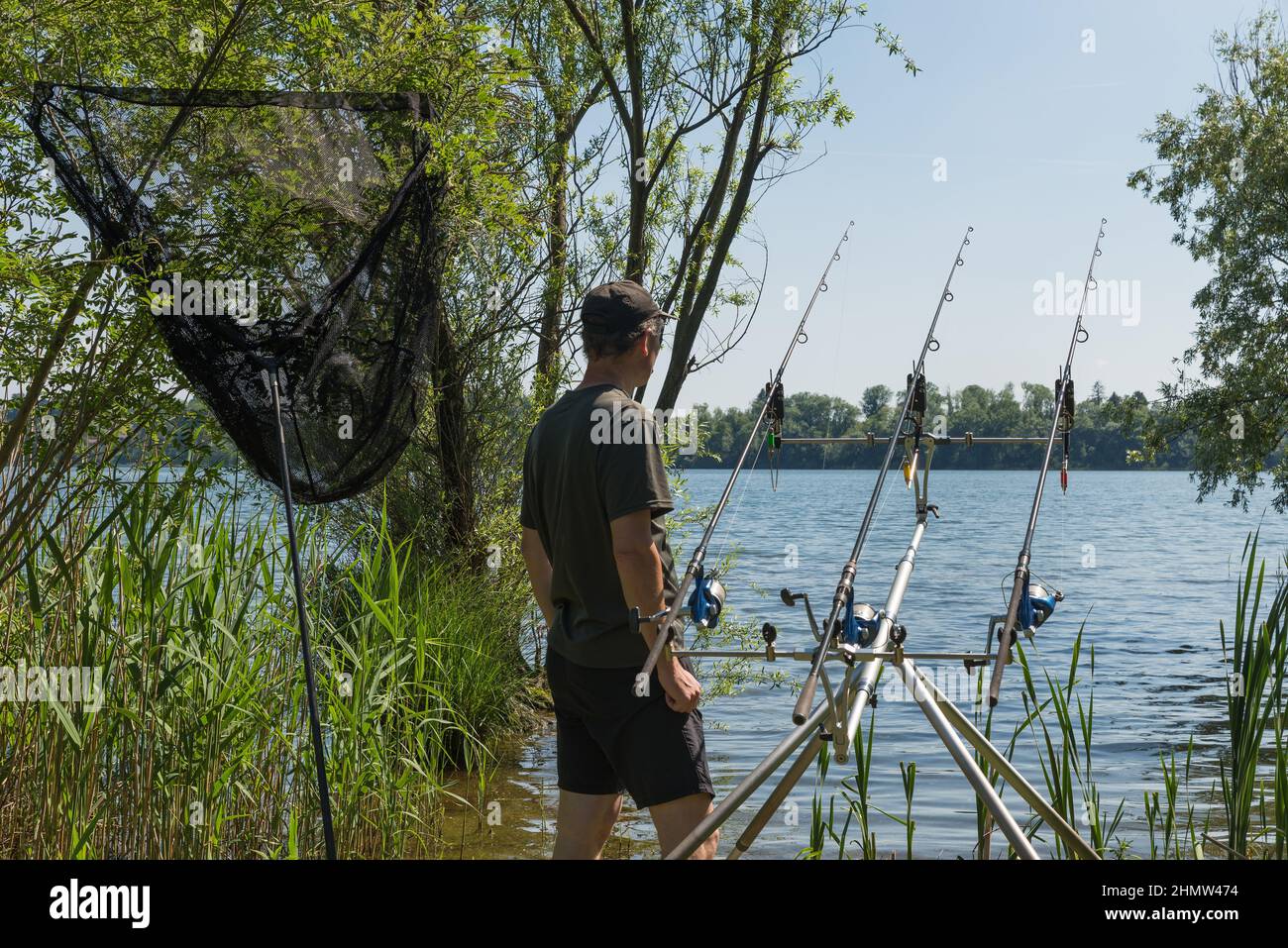 Fishing adventures, carp fishing. Concept of waiting and patience. Man fishing on the lake using modern equipment Stock Photo