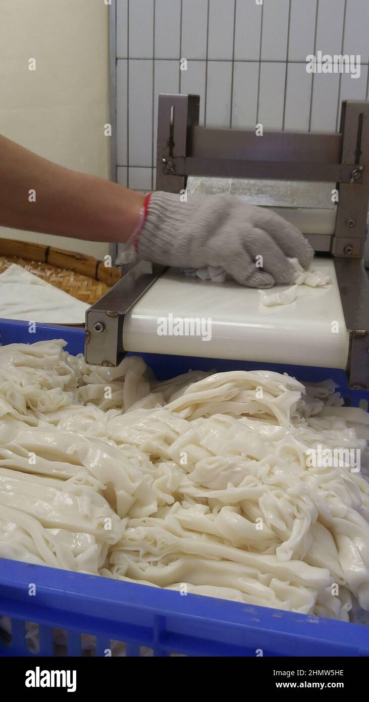 Traditional Chinese cuisine, rice noodles, is being processed Stock