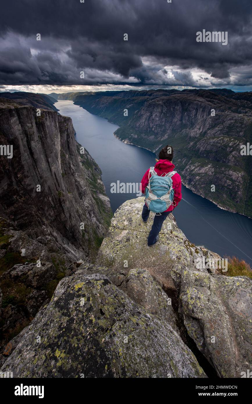 Visiting Norway, Backpacker on top of Eagle Head Viewpoint near Kjeragbolten Stock Photo
