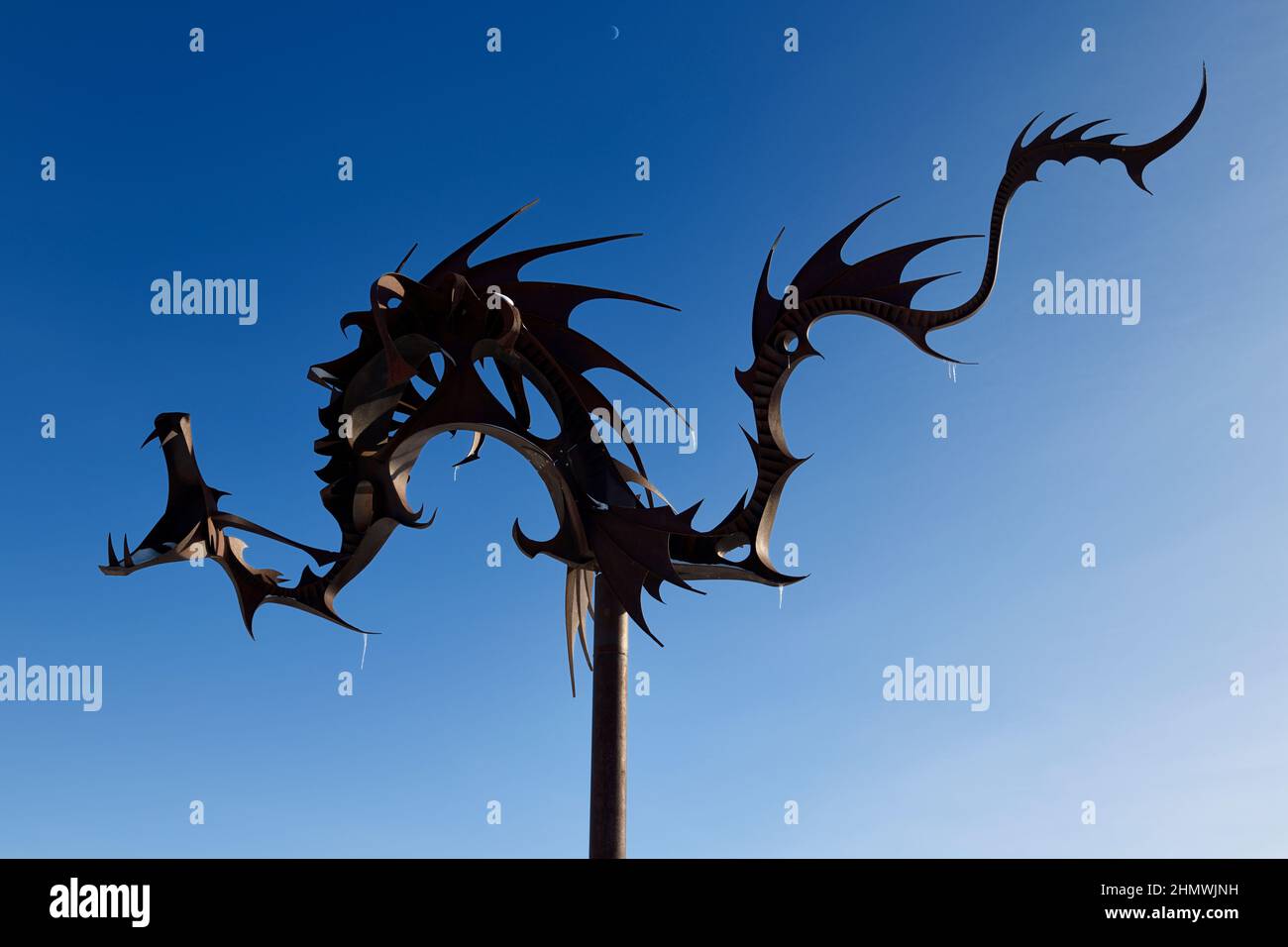 Rusted steel Sea Serpent sculpture at Heritage Park on Kempenfelt Bay in Barrie Ontario against blue sky with moon Stock Photo