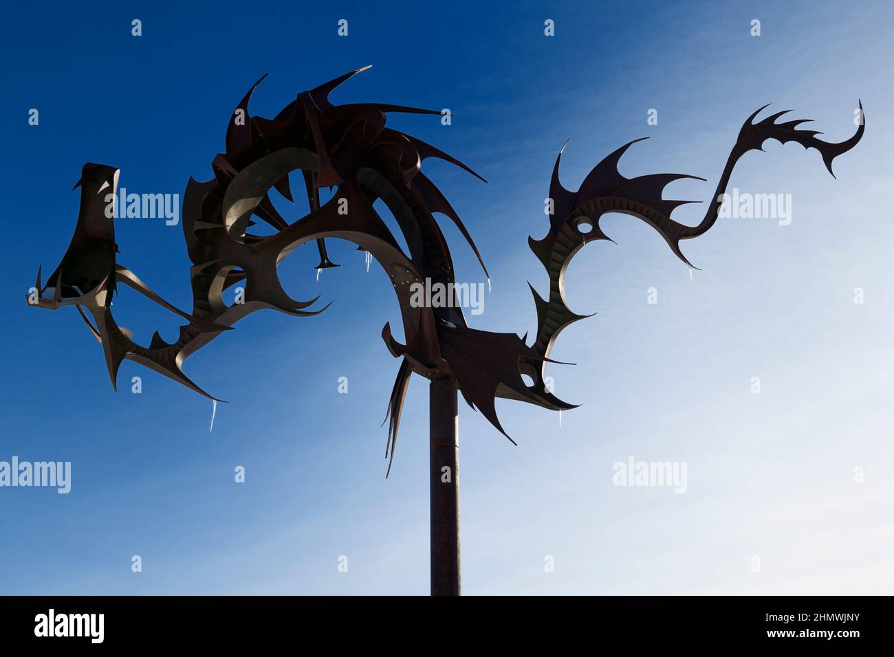 Rusted steel Sea Serpent sculpture at Heritage Park on Kempenfelt Bay in Barrie Ontario against bright blue sky Stock Photo